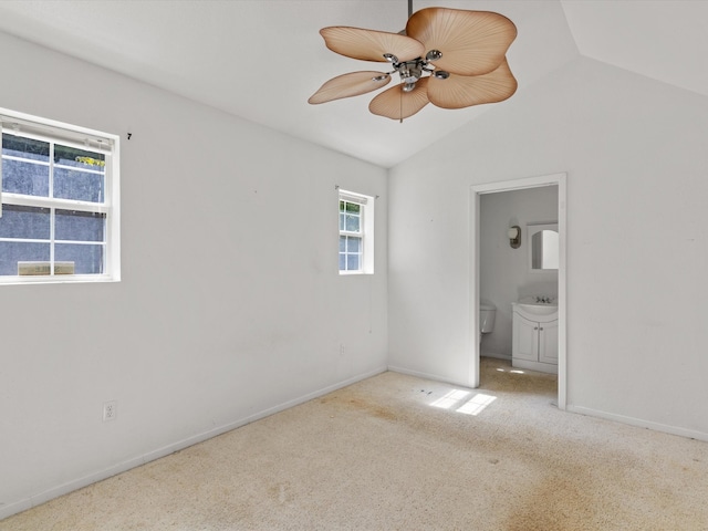 unfurnished bedroom with ensuite bathroom, ceiling fan, light colored carpet, and lofted ceiling