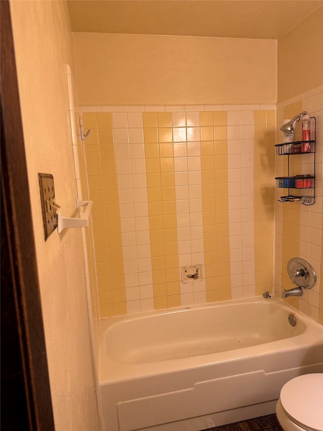 bathroom with toilet and tiled shower / bath combo