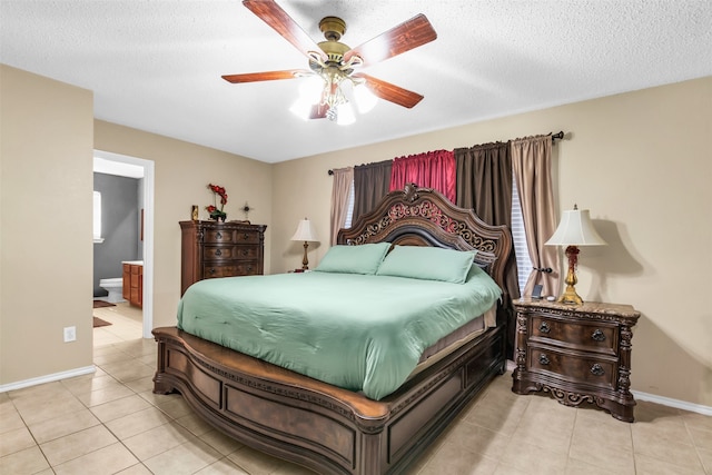 bedroom with ceiling fan, a textured ceiling, ensuite bathroom, and light tile patterned flooring