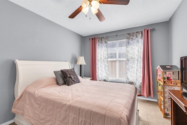 tiled bedroom with a textured ceiling and ceiling fan