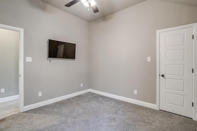 carpeted empty room with vaulted ceiling and ceiling fan