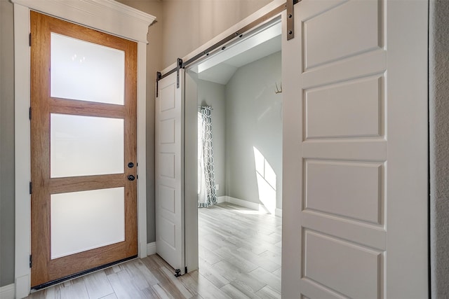 interior space with light wood-type flooring and a barn door