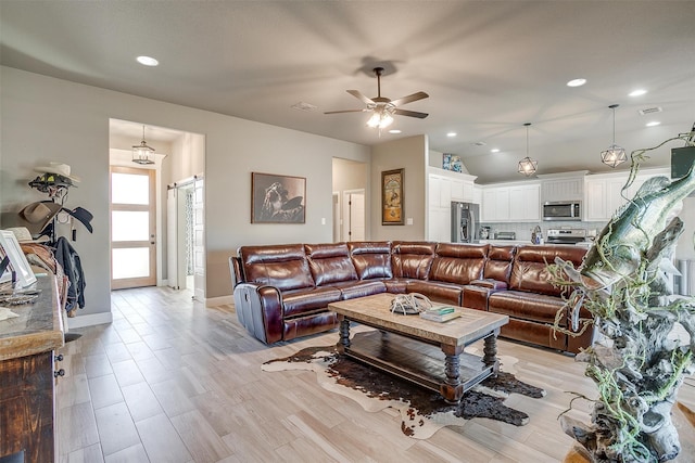 living room featuring ceiling fan and light hardwood / wood-style floors