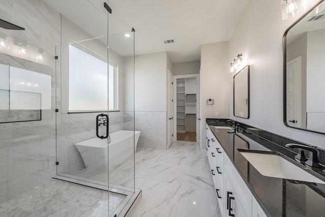 bathroom featuring vanity and independent shower and bath