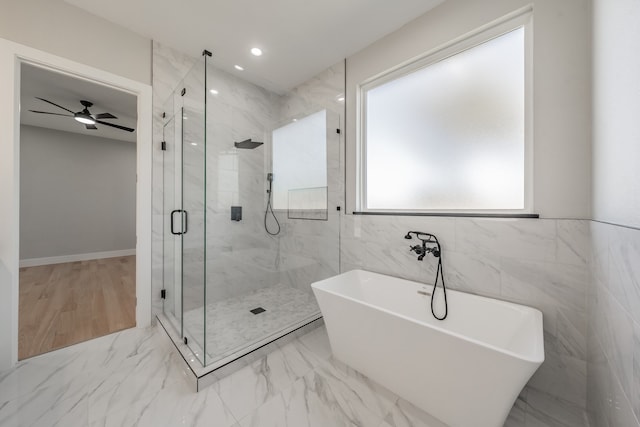 bathroom featuring ceiling fan, tile walls, and plus walk in shower