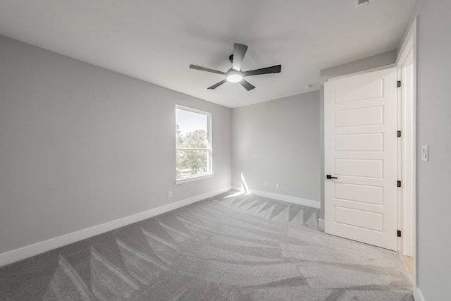 empty room with ceiling fan and light colored carpet