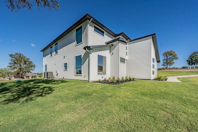 rear view of property with a yard and central AC unit