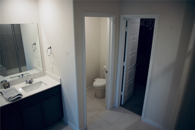 bathroom featuring walk in shower, tile patterned flooring, vanity, and toilet