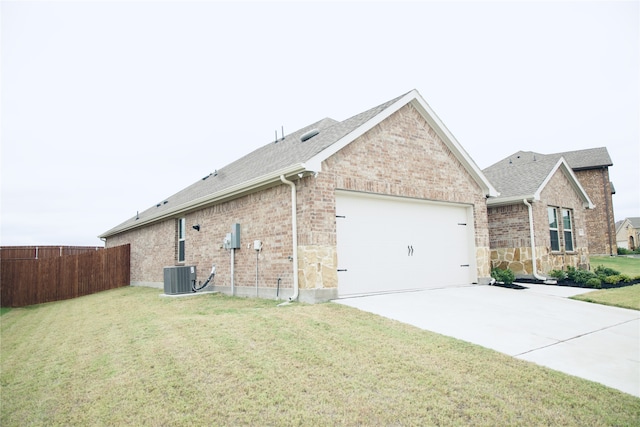 view of side of property with a lawn, cooling unit, and a garage