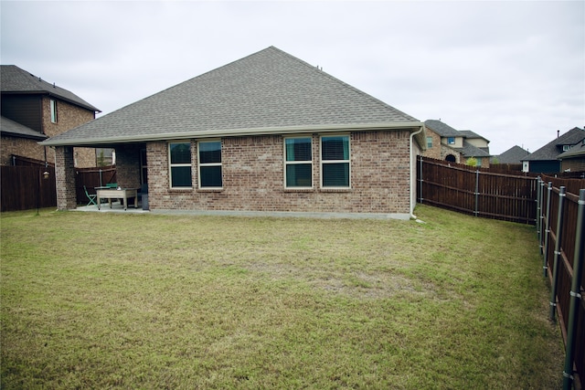 rear view of house featuring a patio area and a yard