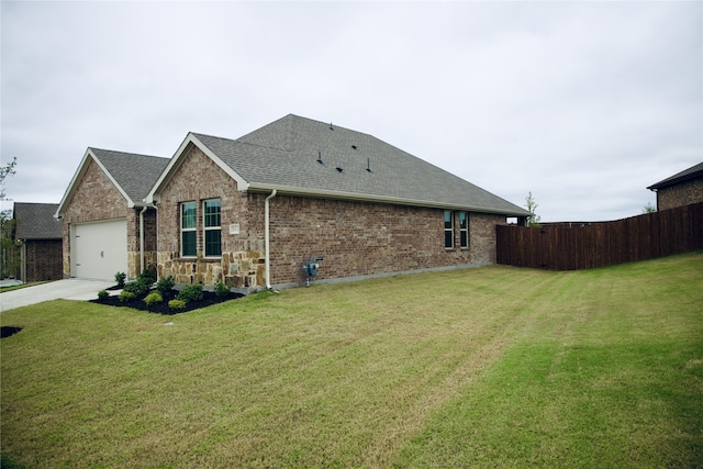 view of side of property with a lawn and a garage