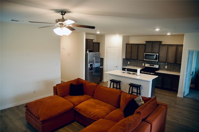 living room featuring ceiling fan, sink, and dark hardwood / wood-style flooring