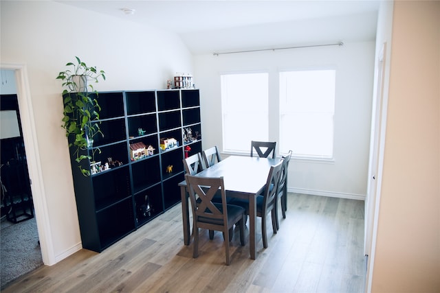 dining area featuring lofted ceiling and hardwood / wood-style floors