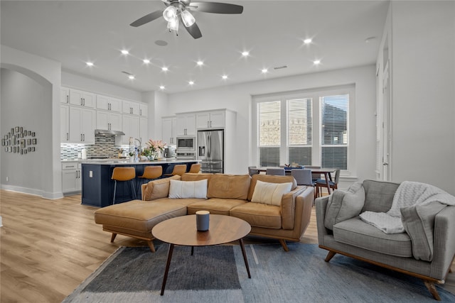 living room featuring light wood-type flooring and ceiling fan