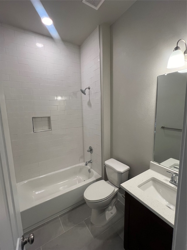 full bathroom featuring tile patterned floors, tiled shower / bath combo, vanity, and toilet