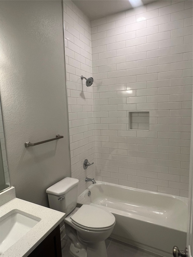 full bathroom with vanity, tiled shower / bath, and toilet