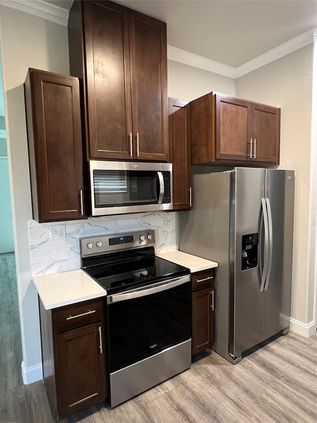 kitchen featuring light wood-type flooring, decorative backsplash, and stainless steel appliances