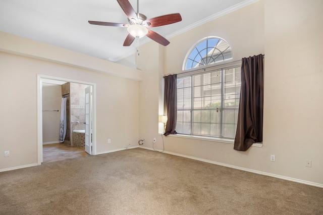 carpeted empty room featuring a high ceiling, ceiling fan, and crown molding