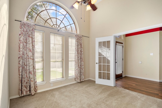 empty room with a healthy amount of sunlight, ceiling fan, and hardwood / wood-style flooring