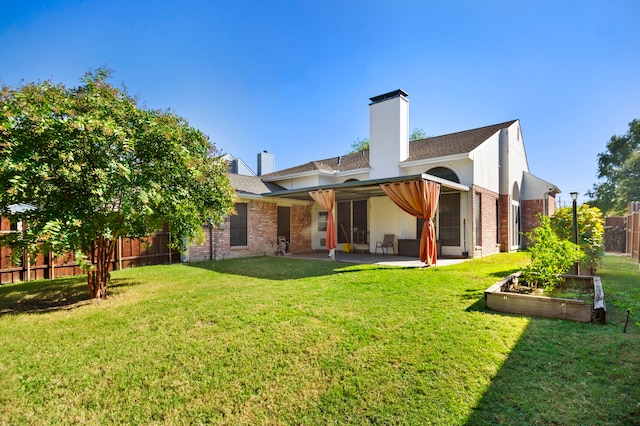 rear view of house featuring a lawn and a patio area