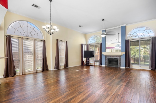 unfurnished living room with ornamental molding, ceiling fan with notable chandelier, and dark wood-type flooring