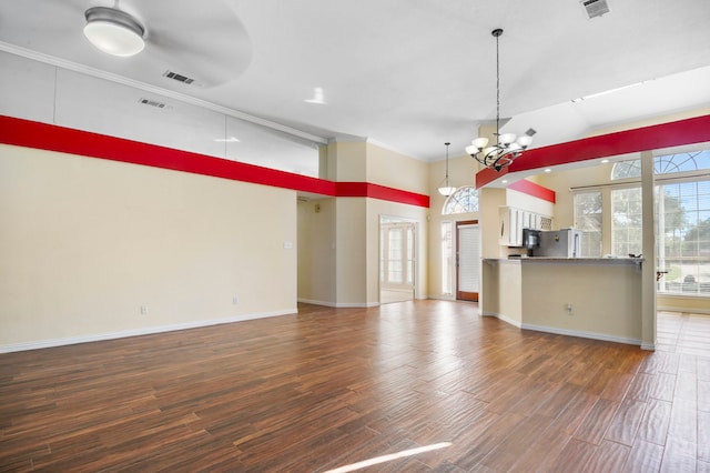 interior space featuring white refrigerator, crown molding, decorative light fixtures, dark hardwood / wood-style floors, and a notable chandelier