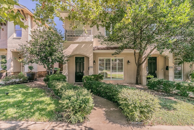 view of front of property with a balcony and a front lawn