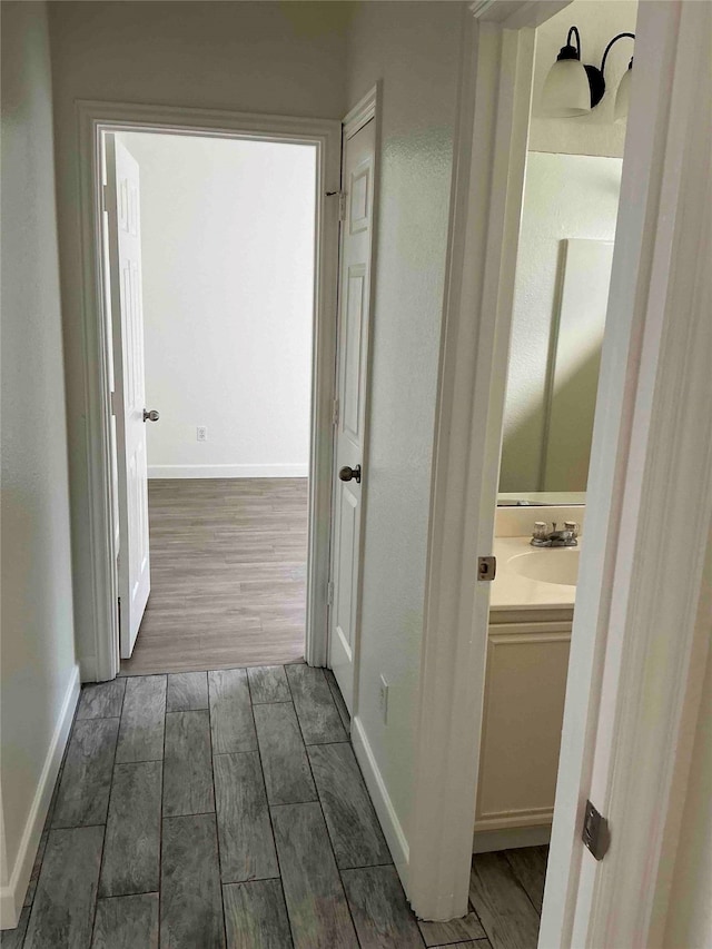 hallway with sink and dark wood-type flooring