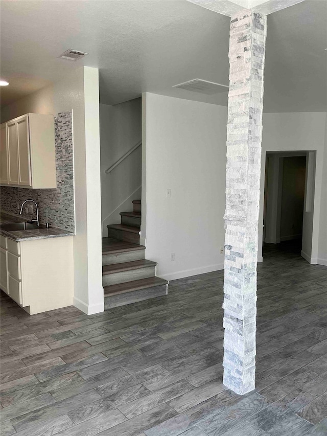 interior space featuring decorative columns, hardwood / wood-style floors, and sink