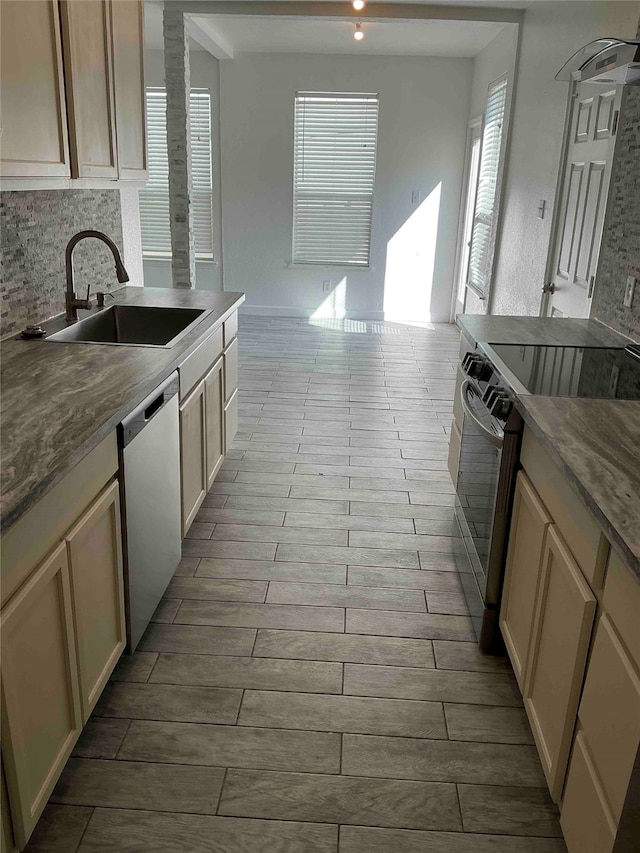 kitchen featuring light wood-type flooring, appliances with stainless steel finishes, tasteful backsplash, and sink