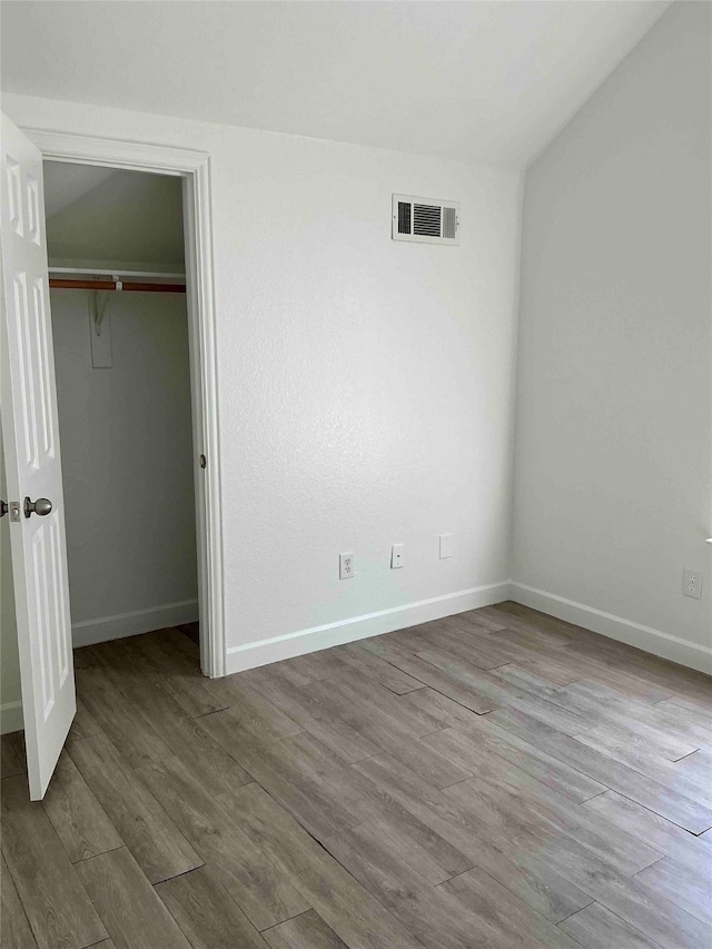 unfurnished bedroom featuring a closet and hardwood / wood-style flooring