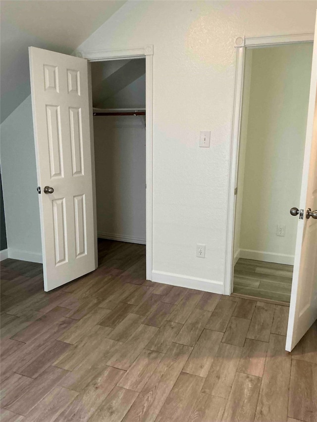 unfurnished bedroom featuring wood-type flooring and a closet