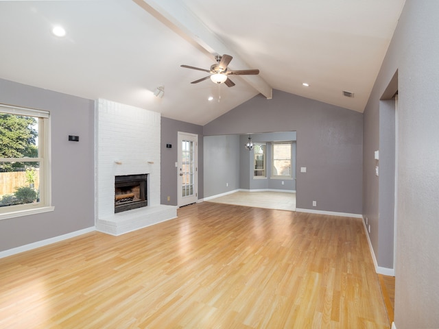 unfurnished living room featuring a brick fireplace, lofted ceiling with beams, light hardwood / wood-style flooring, and ceiling fan