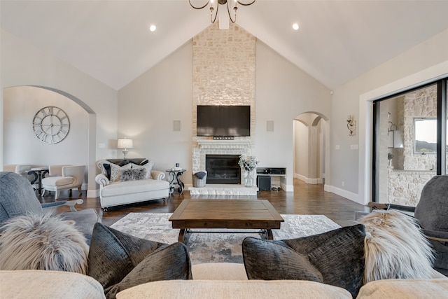 living room featuring dark hardwood / wood-style floors, high vaulted ceiling, and a large fireplace