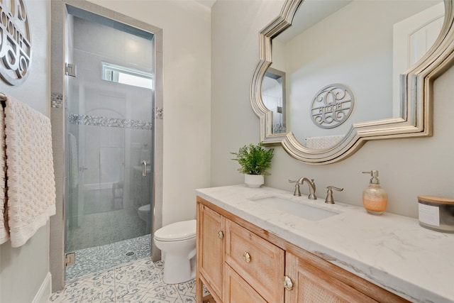 bathroom with a shower with shower door, vanity, and toilet