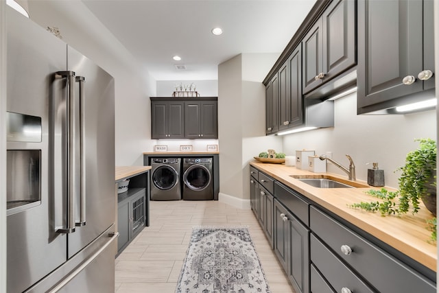 kitchen featuring high quality fridge, butcher block countertops, washer and clothes dryer, and sink