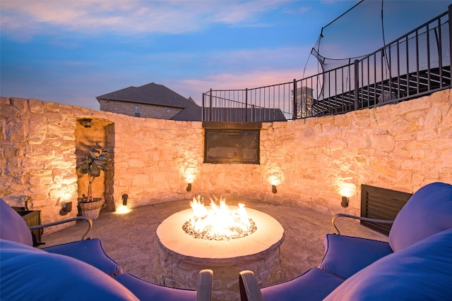 patio terrace at dusk featuring a fire pit