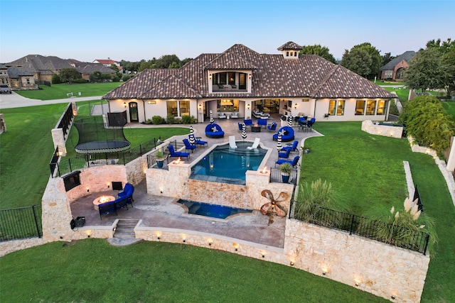 view of pool with a lawn, an in ground hot tub, and a patio