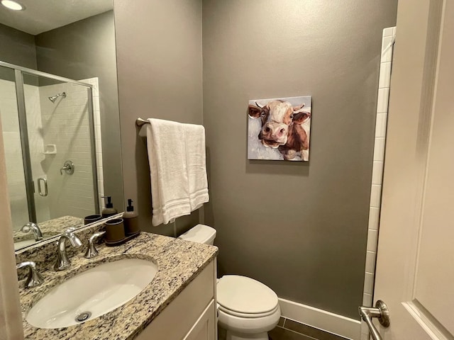 bathroom with vanity, tile patterned floors, toilet, and walk in shower