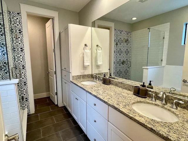 bathroom featuring vanity, a tile shower, and tile patterned flooring