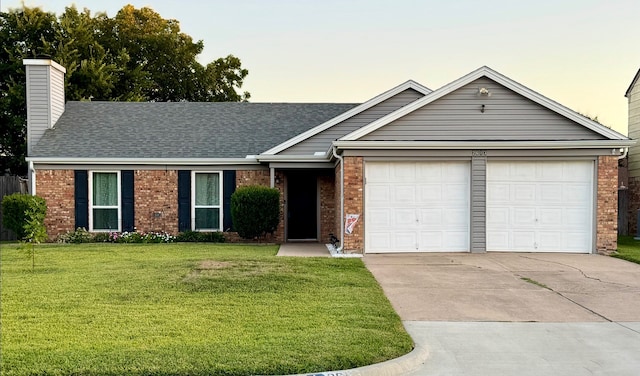 ranch-style home featuring a garage and a yard