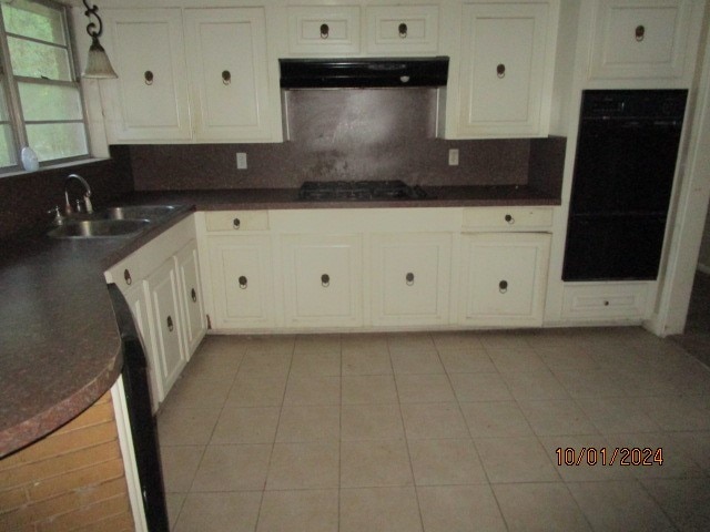 kitchen with decorative backsplash, white cabinets, exhaust hood, black appliances, and sink