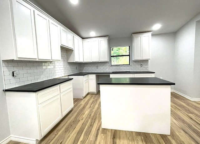 kitchen featuring light hardwood / wood-style flooring, white cabinetry, a center island, and tasteful backsplash