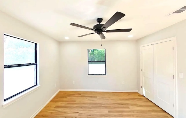 unfurnished bedroom with ceiling fan, light hardwood / wood-style flooring, and a closet