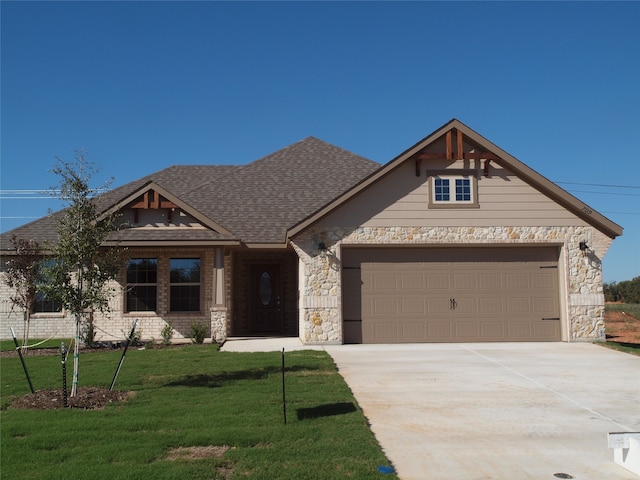 craftsman inspired home featuring a garage and a front lawn