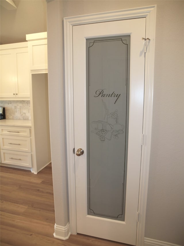 details featuring decorative backsplash and hardwood / wood-style flooring