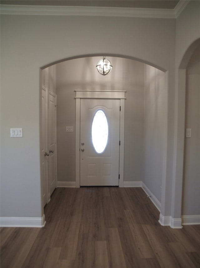 foyer entrance with crown molding and dark wood-type flooring