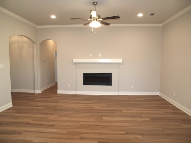 unfurnished living room with ceiling fan, dark wood-type flooring, and crown molding