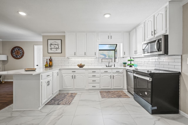 kitchen featuring kitchen peninsula, crown molding, white cabinets, appliances with stainless steel finishes, and tasteful backsplash