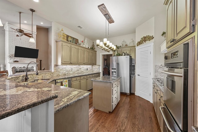 kitchen featuring a center island, dark hardwood / wood-style floors, sink, hanging light fixtures, and appliances with stainless steel finishes